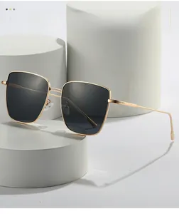 Detail of square gold metal sunglasses frame with sleek temples on white platform