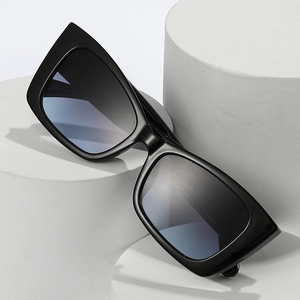 Modern cat eye sunglasses with thick black frames and blue gradient lenses on white display
