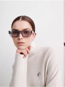 Detail einer grauen quadratischen Sonnenbrille mit transparentem Rahmen und Rollkragen