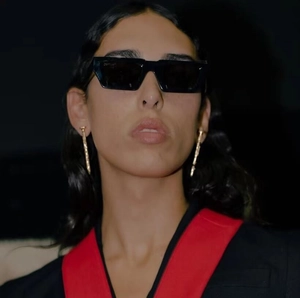 Schicke schwarze eckige Sonnenbrille und goldene Ohrhänger am professionellen Model