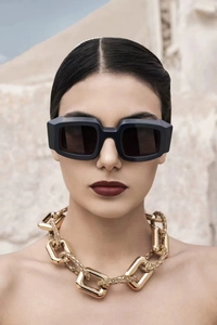 Gros plan de lunettes de soleil noires avec un collier à gros maillons dorés