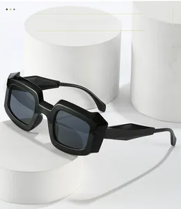 Détail de lunettes de soleil carrées noires avec monture épaisse et branches facettées
