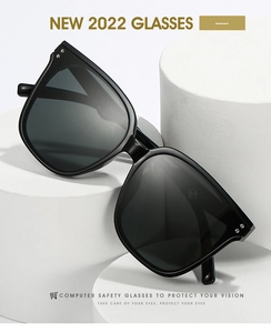 Detail of square black oversized sunglasses with metal rivets and dark lenses