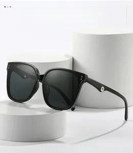 Close-up of black square sunglasses with round metal cutout hinge and rivets