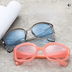 Fashionable oversized sunglasses with transparent frames and colorful lenses on stone surface