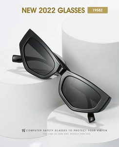 Detail of black geometric cat-eye sunglasses on minimalist white display pedestals