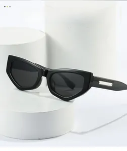 Detail of black geometric cat-eye sunglasses with silver metal trim on white podiums