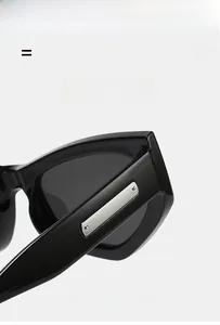 Macro detail of black glossy cat-eye sunglasses with silver metal temples and rivets