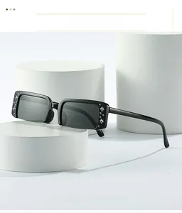 Close-up of semi-rimless sunglasses on a white stand showing sparkling diamond accents