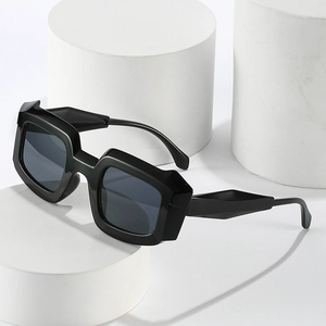 Lunettes de soleil noires à monture carrée épaisse avec verres gris sur support blanc