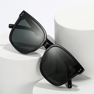 Chic black square oversized sunglasses with silver studs on a white geometric display