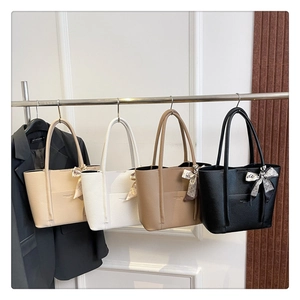 Detail of four colorful litchi pattern leather tote bags with decorative silk scarves