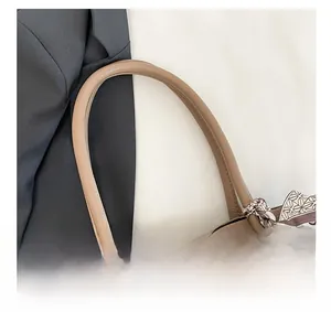 Detail of tan pebble leather tote bag with elegant printed silk scarf on handle