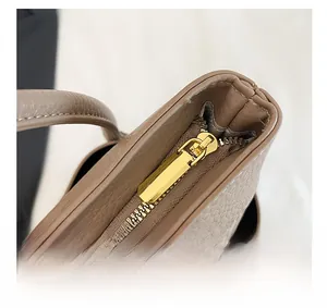 Detail of premium brown lychee pattern leather tote with smooth gold zipper and silk scarf