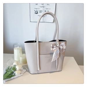 Close-up of cream lychee texture tote bag with elegant silk scarf on handle