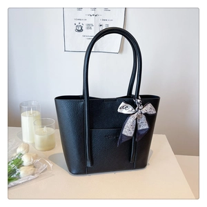 Close-up of black lychee grain leather tote bag with printed silk scarf decoration