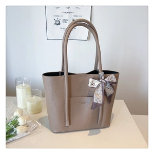 Detail of dark khaki tote bag in pebble leather with decorative geometric scarf