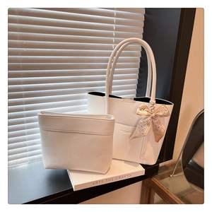 Close-up of white lychee grain leather tote bag with silk scarf and matching inner pouch