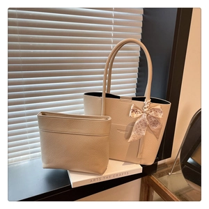 Close-up of beige lychee leather tote bag with interior pouch and decorative silk scarf