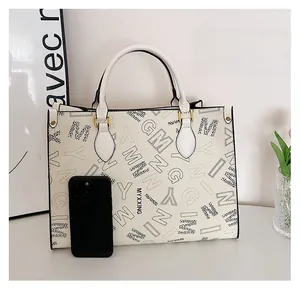 Detailed size comparison of the cream tote bag with black letters next to a mobile phone