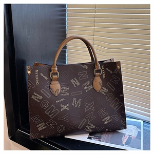 Detailed view of large tote bag with vintage letter print and gold rivet accents