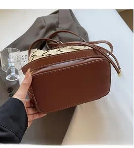 Brown leather bucket bag with beige woven texture detail and slim crossbody strap
