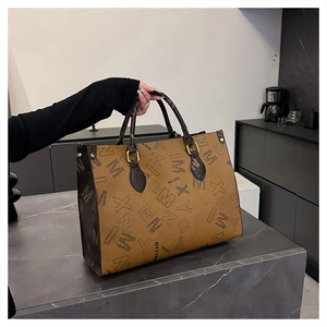 Close-up of a printed tote bag featuring brown leather texture and gold hardware details