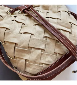Close-up of woven fabric texture and brown leather strap with contrast white stitching