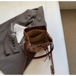 Interior view of woven bucket bag showing beige lining and inner zipper pocket