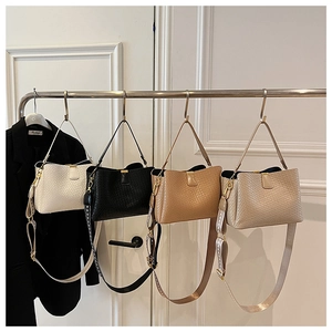 Close-up of woven texture handbags in four colors with stylish patterned shoulder straps