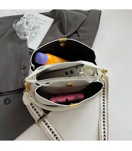 Interior detail of white leather crossbody bag with three compartments showing large capacity
