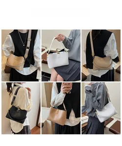 Detail view of woven leather tote bags in beige, white, and black with wide shoulder straps