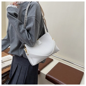 Detail of white woven texture shoulder bag with stylish wide strap and golden hardware