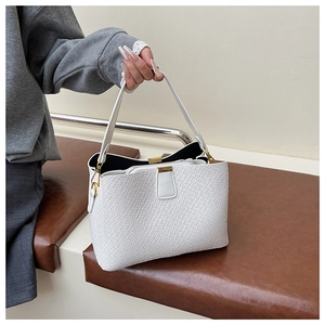 Detail of white embossed leather tote showing gold hardware and inner zipper pocket