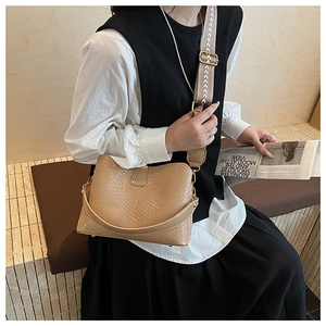 Detail of woven texture faux leather bag with stylish ethnic pattern wide shoulder strap