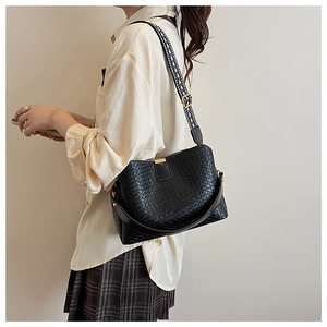 Detail of black woven shoulder bag with geometric jacquard wide strap and soft faux leather