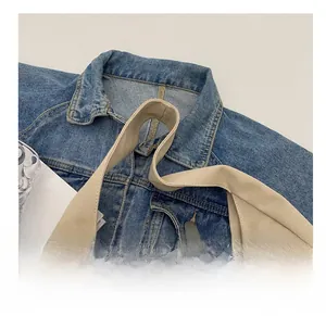 Detailed close-up of wide beige canvas strap showing woven texture on denim fabric