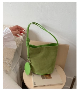 Detail view of fruit green frosted leather bucket bag with matching round coin purse