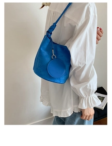 Blue matte leather bucket bag with knotted strap and circular coin purse detail