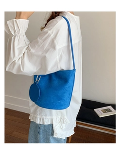 Detail of blue matte leather bucket bag with a matching round pouch for women