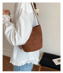 Brown matte bucket bag detail showing soft texture and single shoulder strap design
