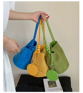 Detailed trio of matte leather bucket bags in blue, yellow, and green with tie handles