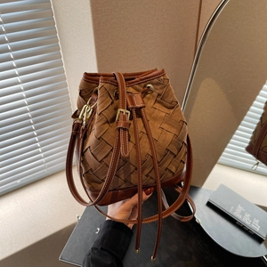 Deep brown woven suede bucket bag with leather base and adjustable shoulder strap