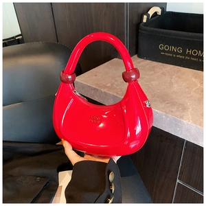 Dettaglio borsa hobo rossa lucida con finiture sferiche decorative sui manici