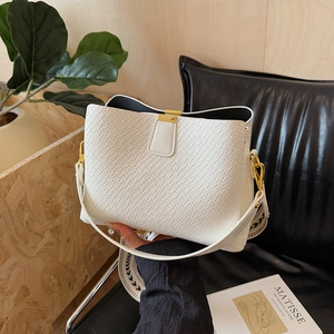 White crocodile embossed bucket bag with wide geometric strap and gold metal hardware