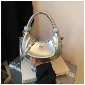 Dettaglio della borsa a mezzaluna argento metallizzato con logo su valigetta