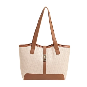2025 summer tote bag with woven texture, brown leather trim, and gold clasp
