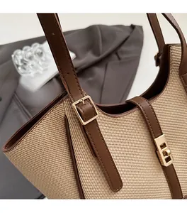 Close-up of premium pale gold hardware and twist-lock on woven leather tote bag