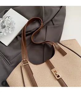 Detail of adjustable leather strap and golden buckle on woven stripe tote bag