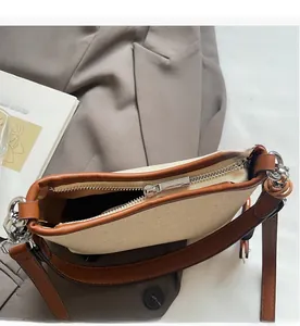 Detailed top view of the smooth silver zipper on a minimalist canvas and leather bag